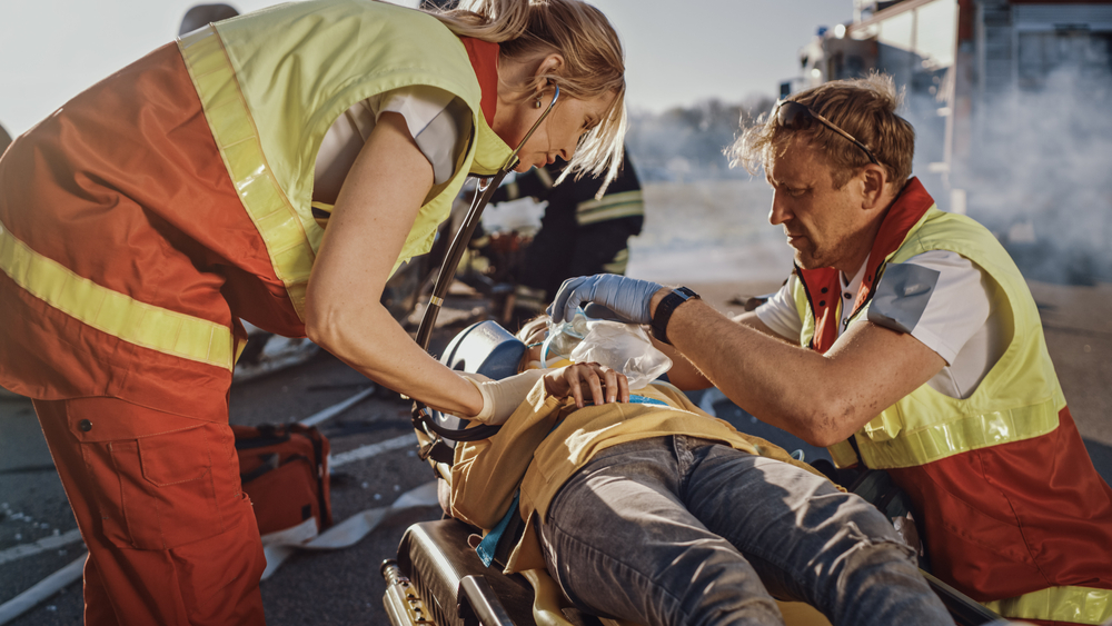 medical representative giving first aid to an injured man