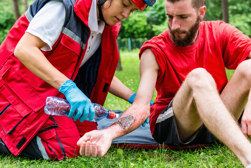 medical worker treating burns on male's hand